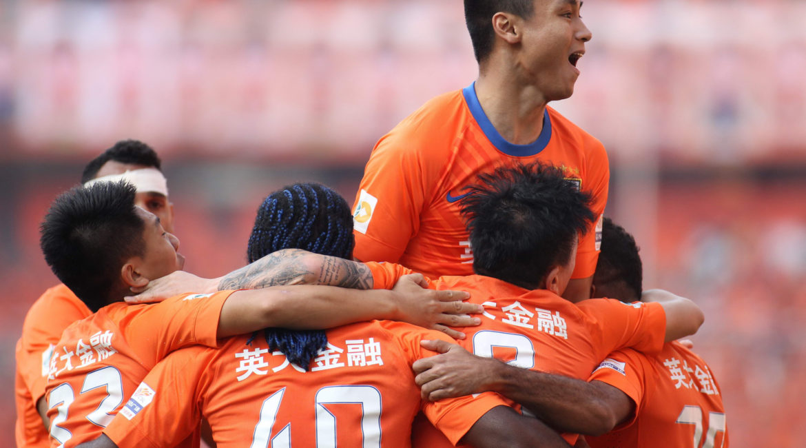 CORRECTION: IDENTITY OF TEAM CELEBRATING
Players of Shandong Luneng Taishan Football Club celebrate a goal against China's Guangzhou Evergrande Football Club before losing the China Super League final match to them in Jinan, east China's Shandong province on October 6, 2013. Guangzhou Evergrande won 4-2.  CHINA OUT   AFP PHOTO        (Photo credit should read STR/AFP/Getty Images)